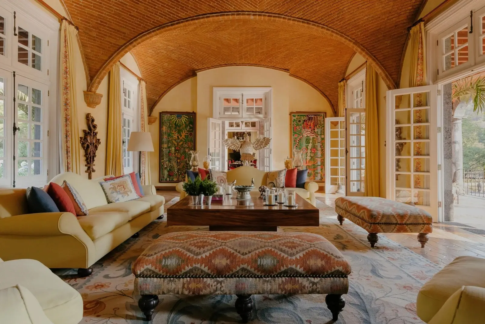 A palace drawing room with a vaulted ceiling, patterned sofas and tall shuttered windows