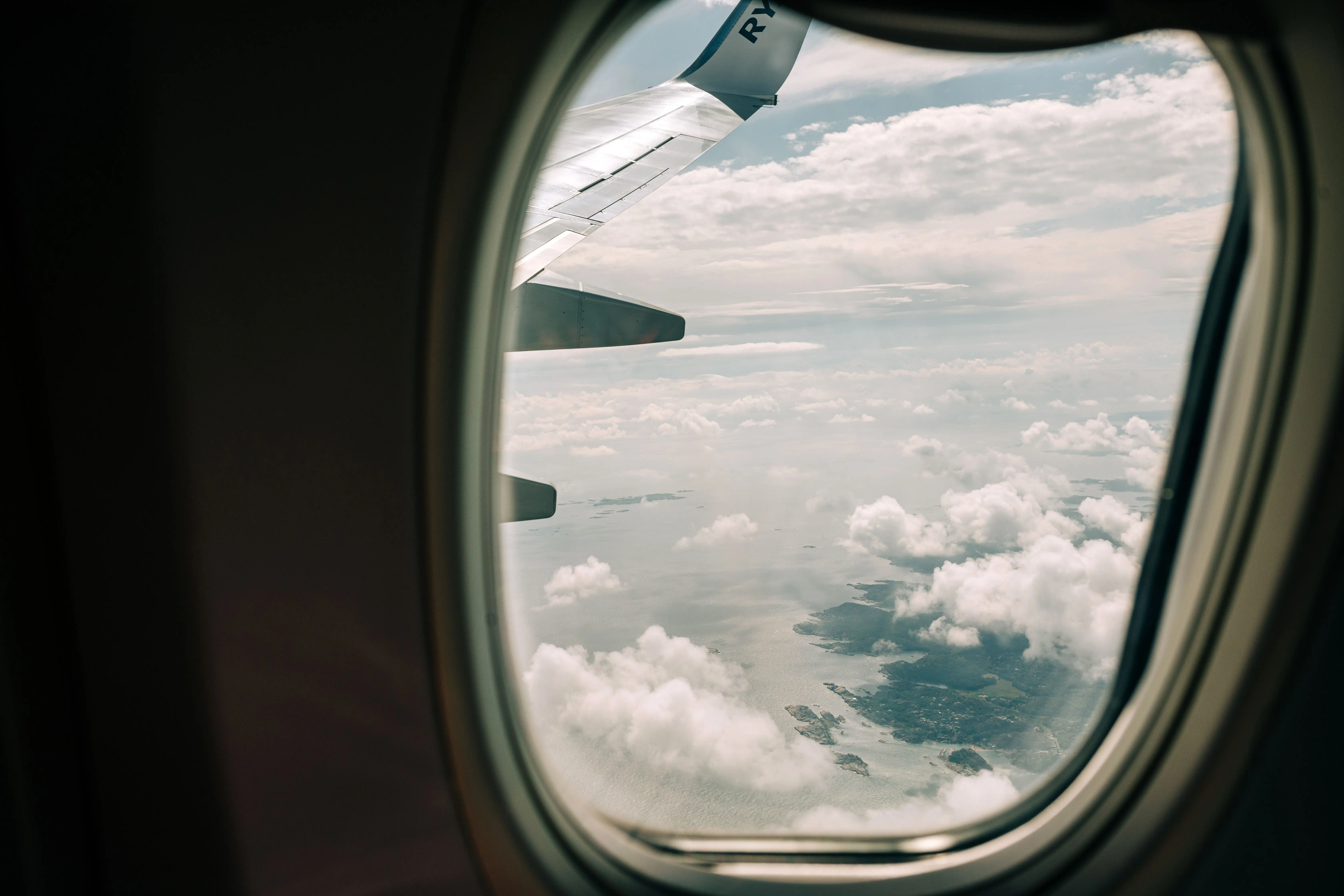 Clouds and blue sky through an aeroplane window